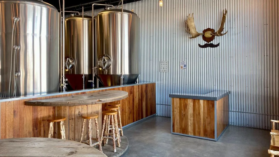 Stainless steel tanks and wood tables inside HooDoo's taproom